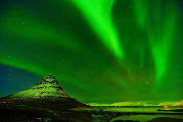 View of the northern light at night at Kirkjufell Mountain in Iceland.