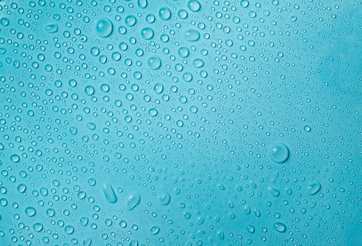 Drops of water on a blue glass texture background