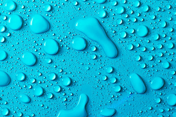 Drops of water on a blue glass texture background