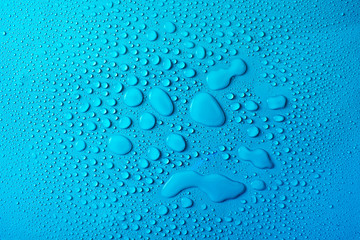 Drops of water on a blue glass texture background