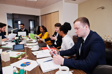 Multiracial young creative people in modern office. Group of young business people are working together with laptop, tablet. Successful freelancers team in coworking.