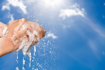 Man washing hands in clean water on blue background