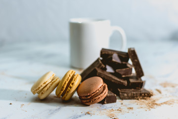 tasty sweet macarons with cup of coffee on background.