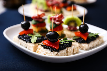 Tasty canapes on plate, closeup