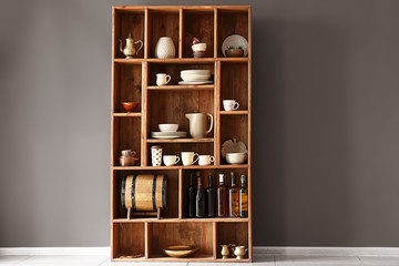 Open cupboard with clean dishes near color wall in kitchen - obrazy, fototapety, plakaty