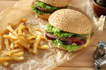Tasty fresh burgers and french fries on table