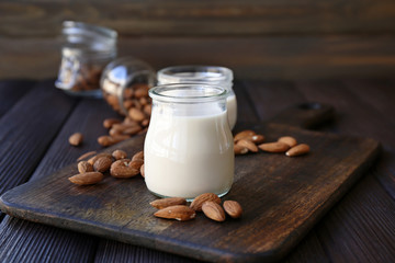 Jars of healthy almond milk on table