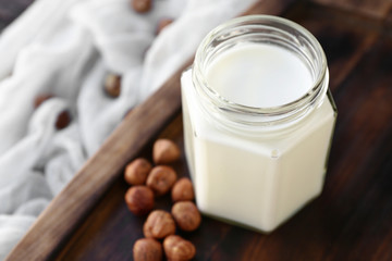 Jar of healthy hazelnut milk on table