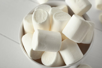 Fototapeta na wymiar Bowl with tasty marshmallows on white table, closeup