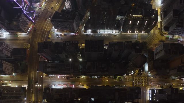 Aerial above Hong Kong downtown city streets by night, overhead view