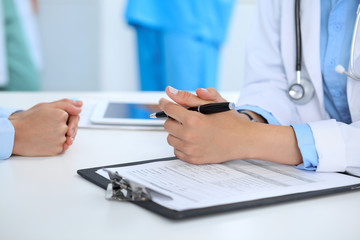 Obraz premium Doctor and patient discussing something, just hands at the table, white background