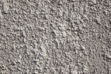 The close up texture of the plastered facing of the stone surface of the wall.
