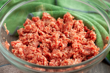 Minced meat is depicted in close-up. Minced beef and pork in a bowl for cooking. Lots of ground beef in glass dishes in the kitchen.