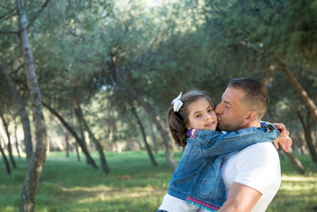 Handsome father and his pretty daughter pose in the park