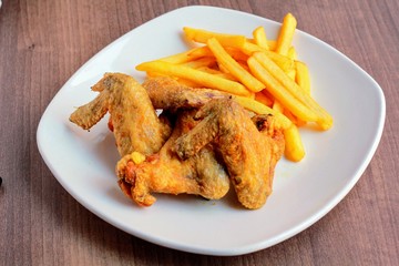 Alitas de pollo fritas con patatas