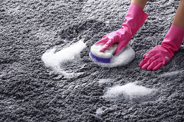 Woman cleaning carpet at home