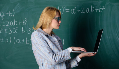 Learn it easy way. Woman teacher wear eyeglasses holds laptop surfing internet. Digital...