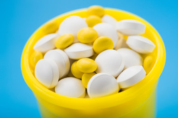 Closeup of white and yellow vitamins pills