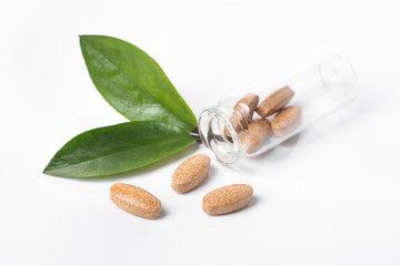 Herd medical pills and capsule with green leaves isolated