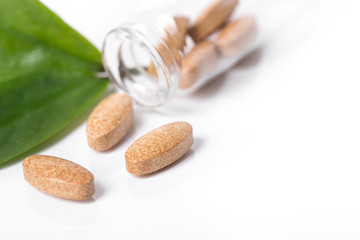 Herd medical pills and capsule with green leaves isolated