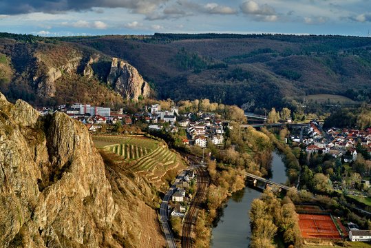 scenic aerial view from the rock Rotenfels down to the river Nahe and the small city of Bad Muenster am Stein-Ebernburg with vivid cloudy sky, the rock Rheingrafenstein can be seen in background