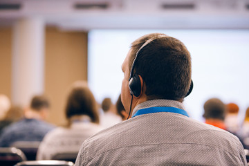 Business man is listen seminar at conference using headphones  for translation 