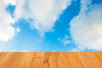 Old Wooden table with blue sky white cloud background.