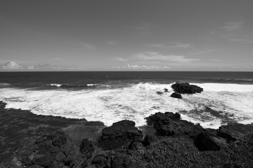 Waves crashing rocks in black and white