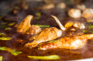 Cooking and making a traditional Spanish Paella over open fire.