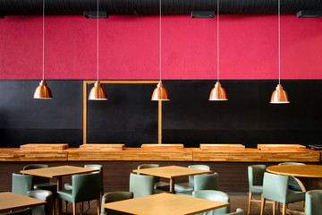 Interior design detail. Some nice copper color lamps hanging in a red and blck room