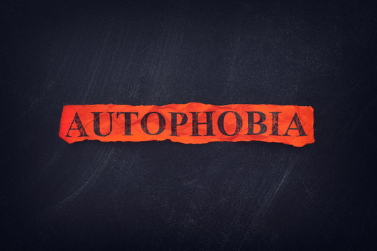 Word Autophobia on red torn piece of paper
