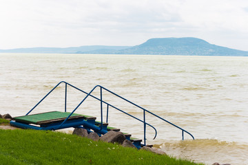 Lake Balaton with pier stairs with the Badacsony mountain in a rainy day in Hungary