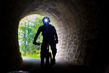 Croatien, Istria, Parenzana Biketrail, Mountainbiker wearing headlamp in tunnel © mmphoto