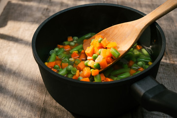 Fresh vegetable soup with sausage on wood. Whole background.