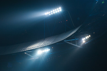 Stadium lights against dark night sky background. Soccer match lights.