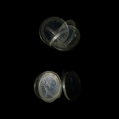 Spinning coin in stroboscopic light. Italian one euro, close up