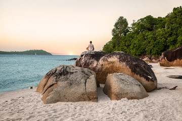 Man Meditating and doing Yoga Exercises on beach - obrazy, fototapety, plakaty