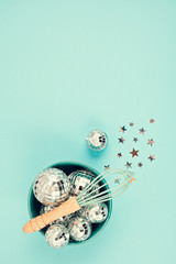 Flat lay with disco balls in the bowl with whisk. Party, fun, celebration planning concept