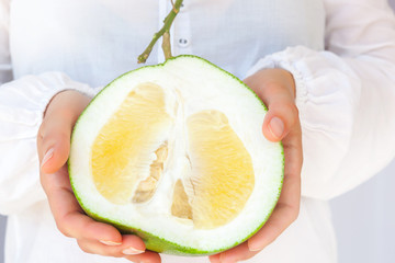 Woman holding healthy pomelo fruit.