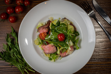 warm salad with veal on a white plate