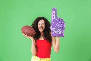 Portrait of pretty woman 20s holding number one fan glove and rugby ball