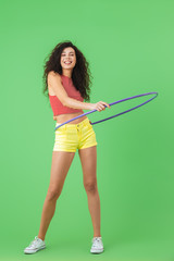 Photo of slim woman 20s wearing summer clothes doing exercises with hula hoop during gymnastics © Drobot Dean