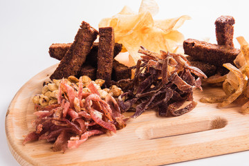 Salty snack to beer on a wooden board on a white background