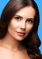 Obraz premium portrait of beautiful young woman with naked shoulders, on blue