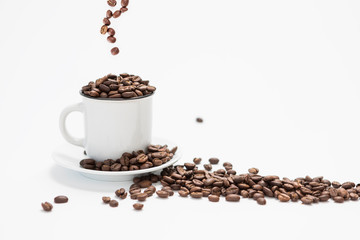 White Coffee Cup With Fresh Coffee Beans Falling into the Cup on a White Background Concept with Copy Space
