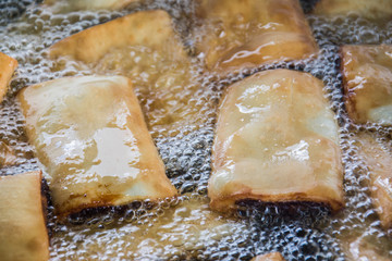 Imqaret - diamond date filled pastries -  frying in hot oil
