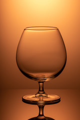 vertical image empty wineglass on orange background