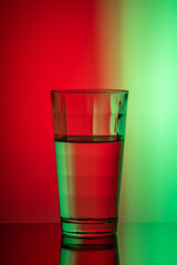 vertical image of glass of water on red-green background