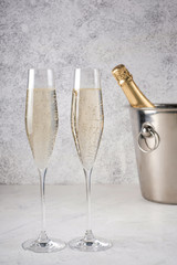 Two glasses of champagne with a champagne bottle in a bucket
