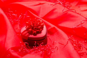 Red heart box on soft red satin background